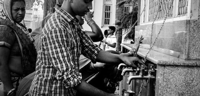 Des Indiens se servent d'eau en libre service dans les rues de Mysore.