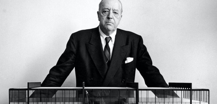Ludwig Mies van der Rohe, architecte, pris en photo devant une maquette.